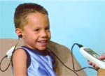 a smiling child getting a hearing screening